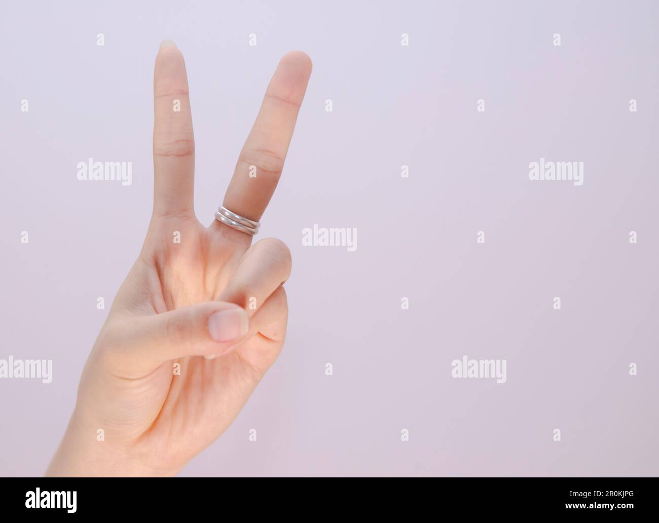closeup woman hand showing two fingers sign language isolated on white
