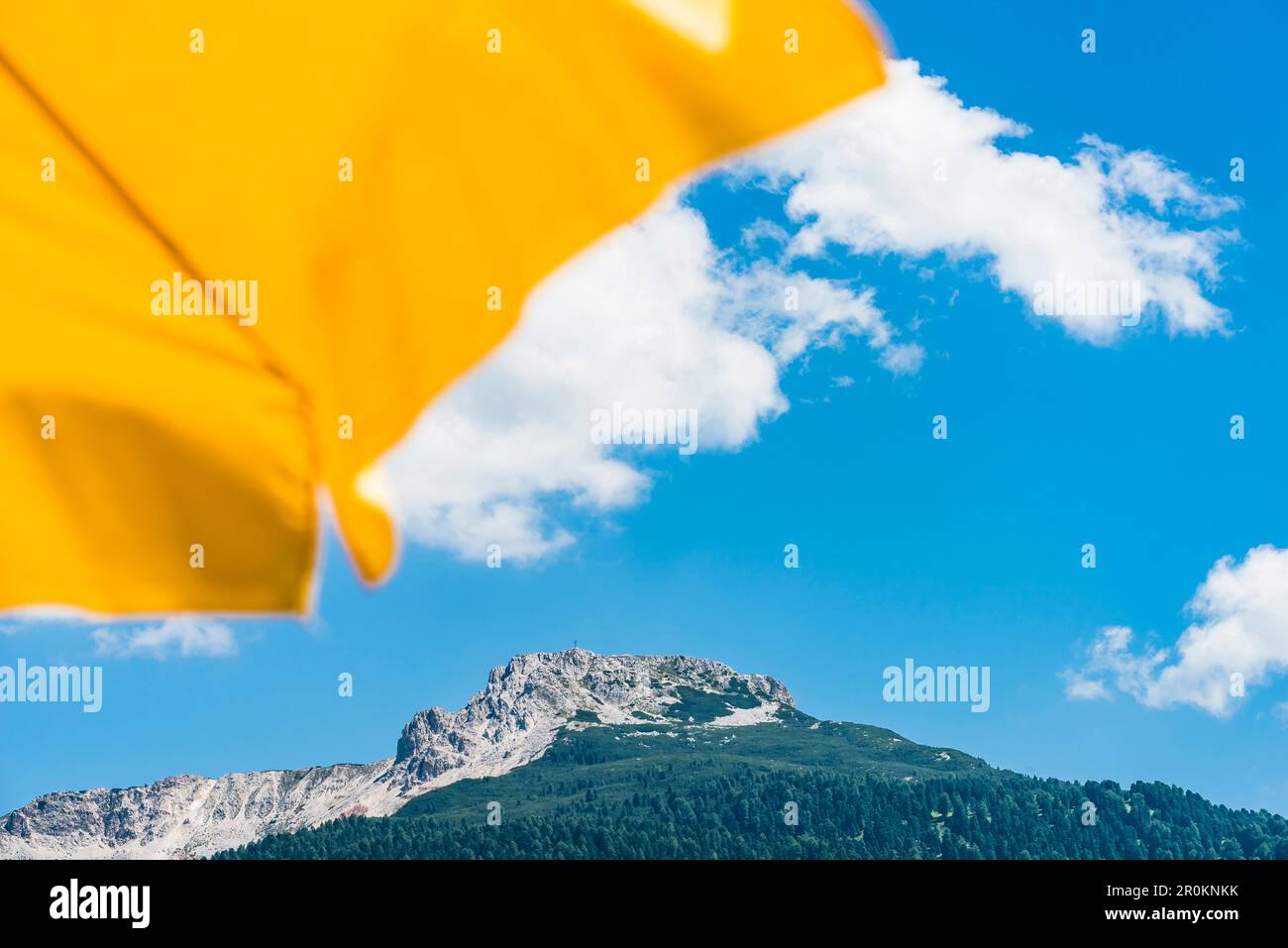 View past a yellow sunshade to the Weisshorn with the adjacent Bletterbach UNESCO World Heritage, Aldein, South Tyrol, Alto Adige, Italy Stock Photo