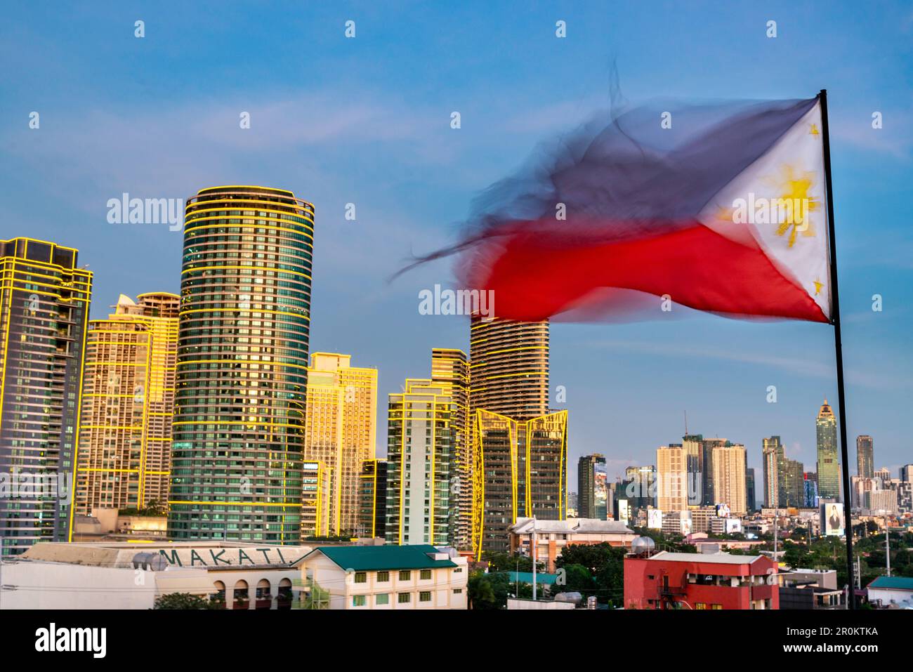 In the early evening afterglow of sunset,the red,blue and white Philippine flag flies,with it's golden sun and stars showing, in the warm breeze, on a Stock Photo