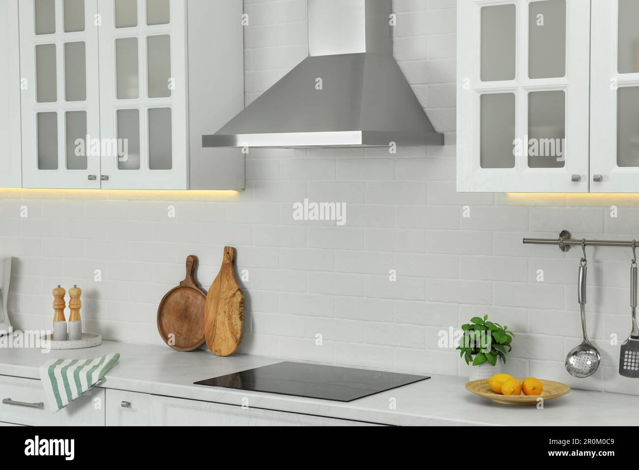 Elegant kitchen interior with modern range hood over cooktop and
