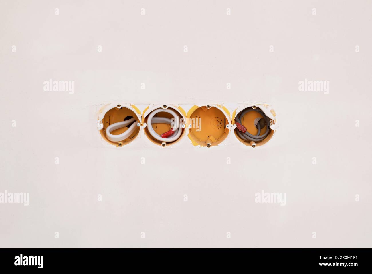 Holes for socket in light grey wall Stock Photo