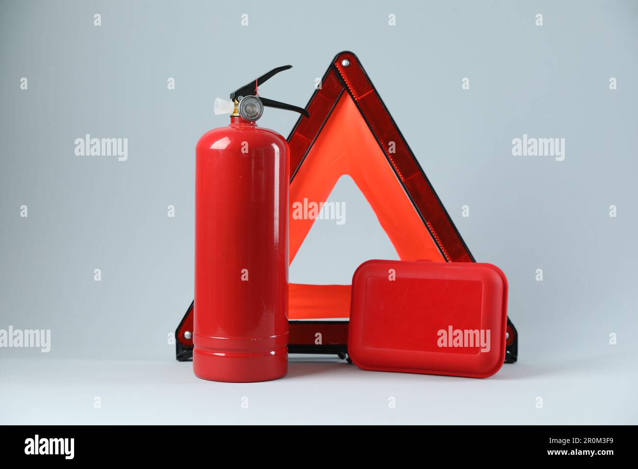 Emergency warning triangle, red fire extinguisher and first aid kit on