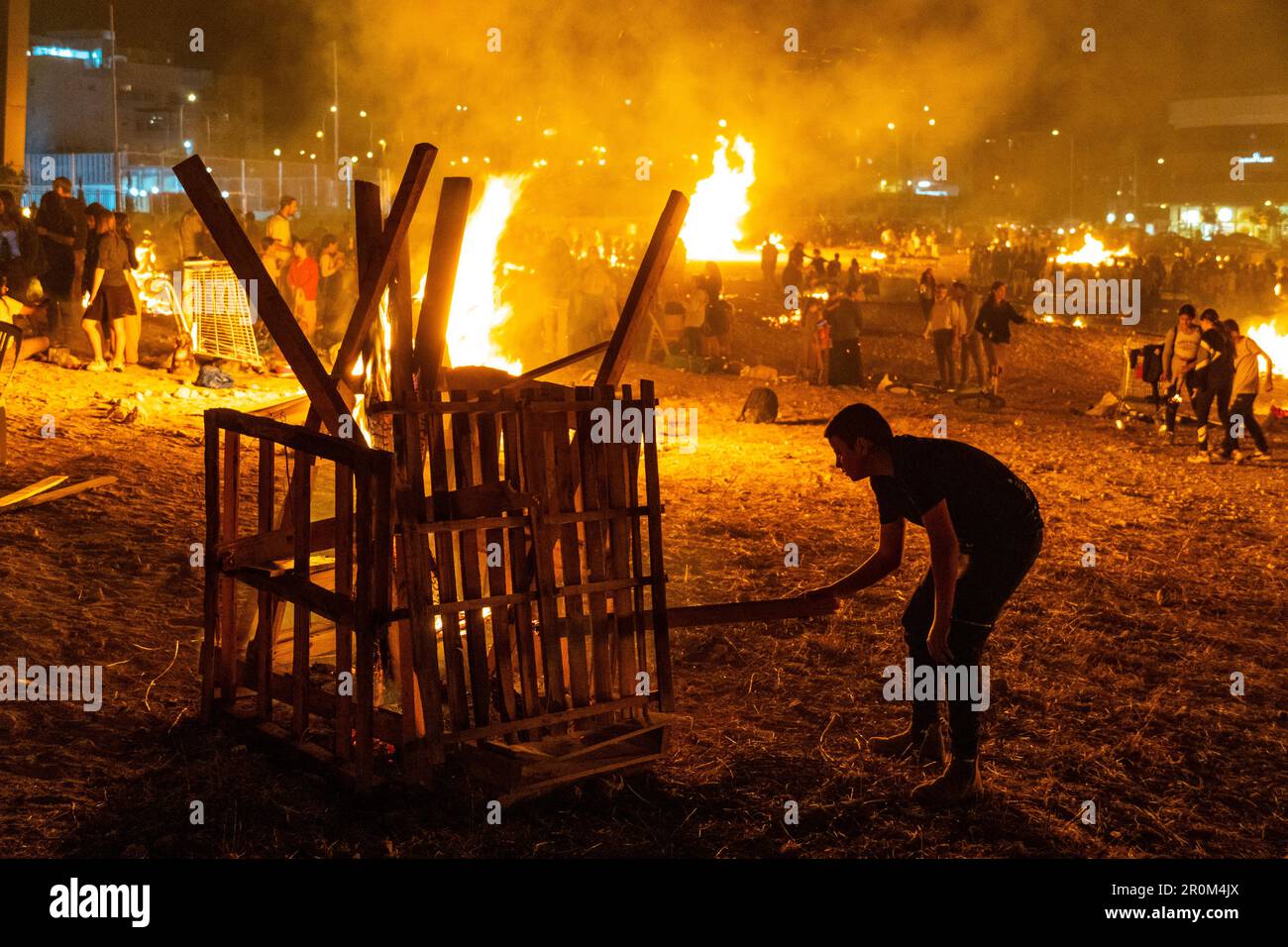 People making fires during the Jewish Holiday of Lag Ba'Omer, which takes place every  18th of Hebrew month Iyar. It is customary during this holiday to make fires. Due to fire hazars, most municipalities allowed fires only in designated sites, sometimes with dozens of different fires lit by different groups. The holiday is extremely popular amongst children, and many groups of children make their own bonfires and prepare food themselves. Stock Photo