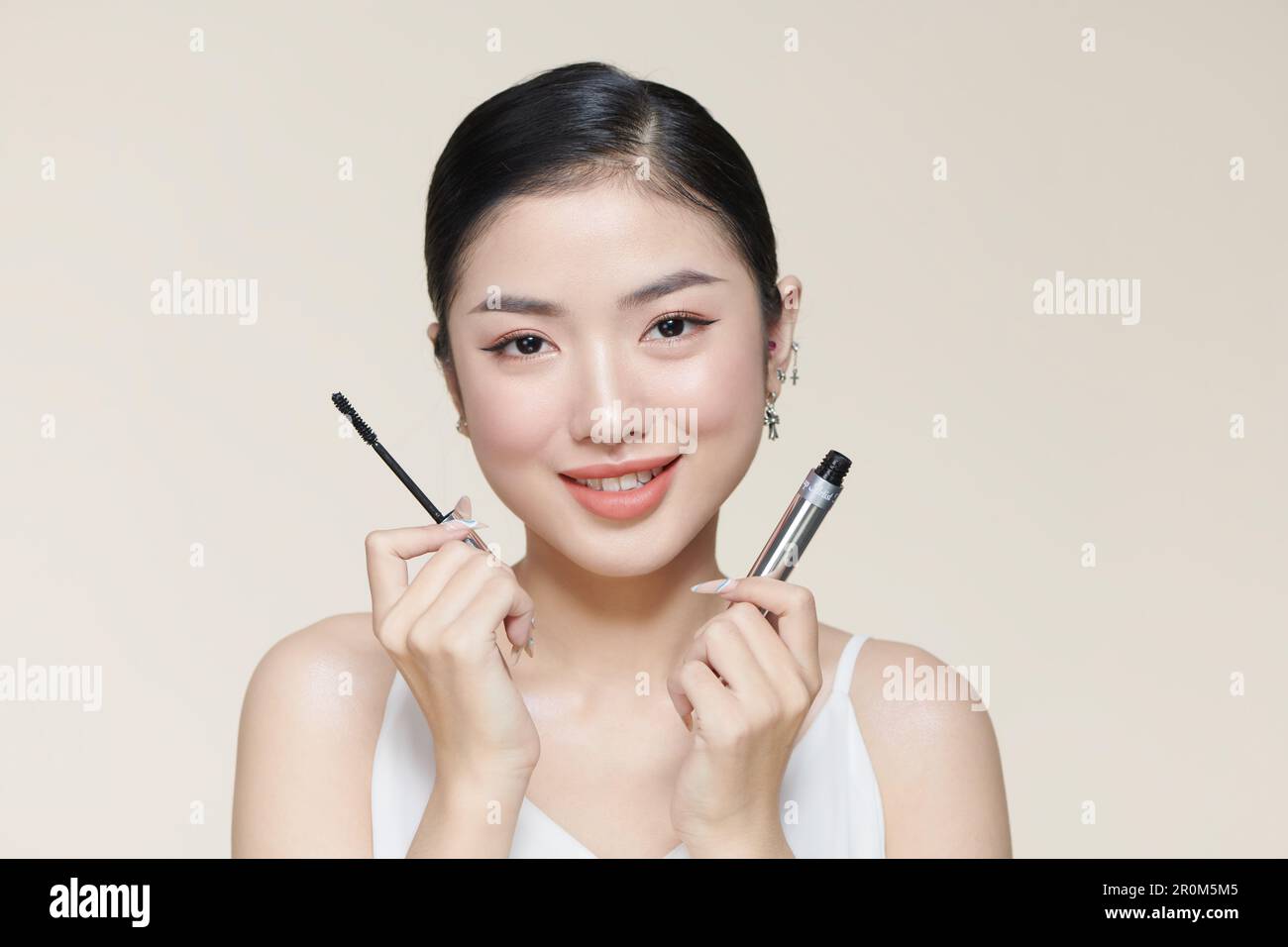 Charming young woman applying mascara. Stock Photo