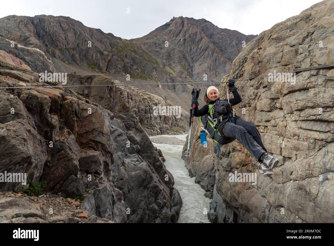 Mountaineer crosses the Rio Tunel on the Paso del Viento with a zip line (Tirolesa), Los Glaciares National Park, Patagonia, Argentina Stock Photo