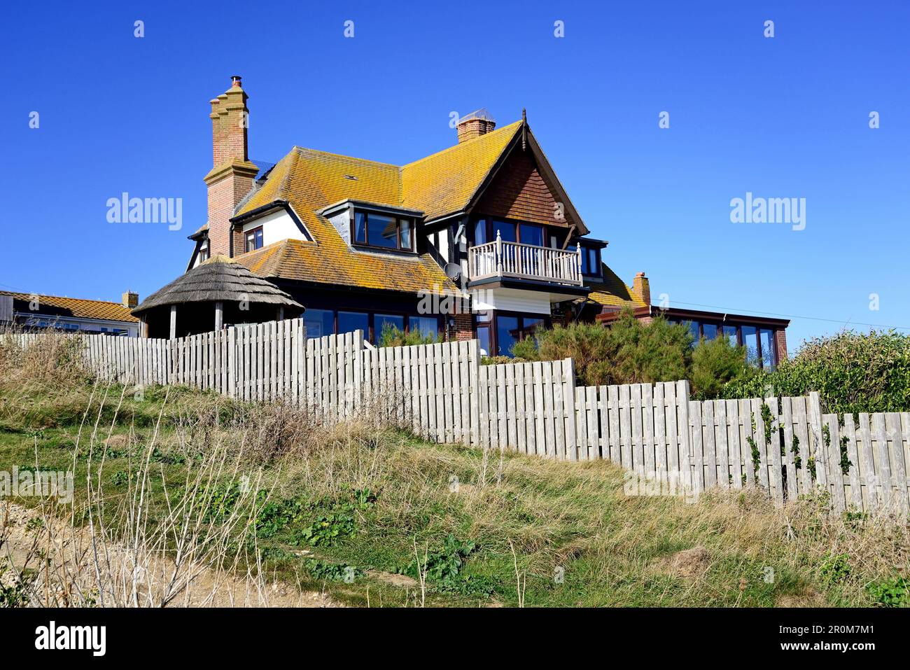 View of a large house on the hillside overlooking the beach, West Bay, Dorset, UK, Europe. Stock Photo