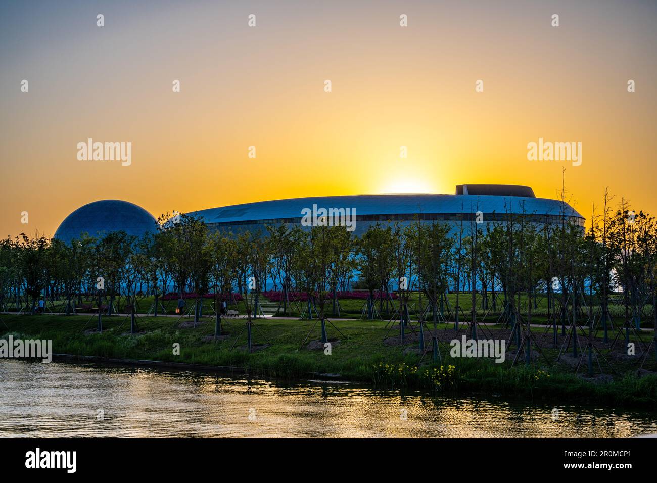 The setting sun goes behind the Shanghai Astronomy Museum in Lingang, Pudong New Area, Shanghai, China. Stock Photo
