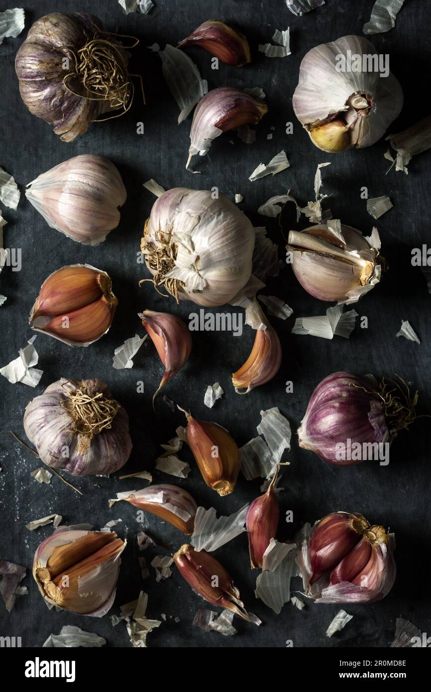 Fresh garlic bulbs and cloves grouped on black background. Flat lay ...