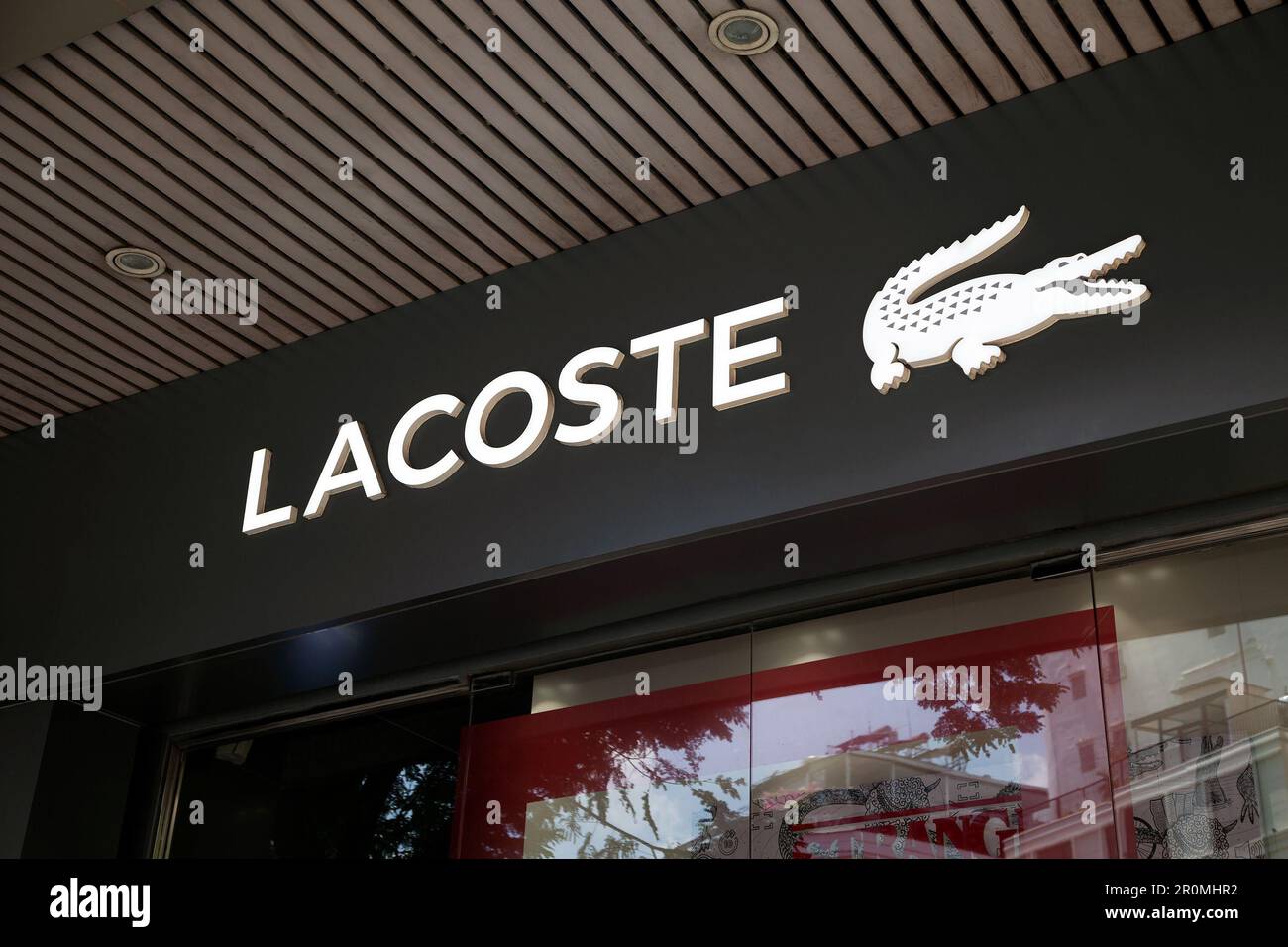 Ho Chi Minh City, Vietnam - May 1, 2023: Fashion store commercial sign with black and white Lacoste logo. Famous luxury fashion brand logotype above a Stock Photo