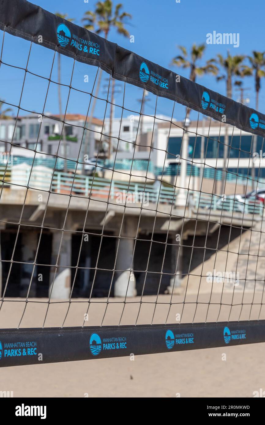 A beach volley net up close with the Manhattan Beach pier in the