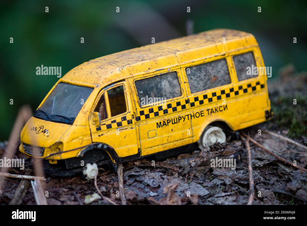 Old discarded and broken toy car in the form of a yellow taxi, small