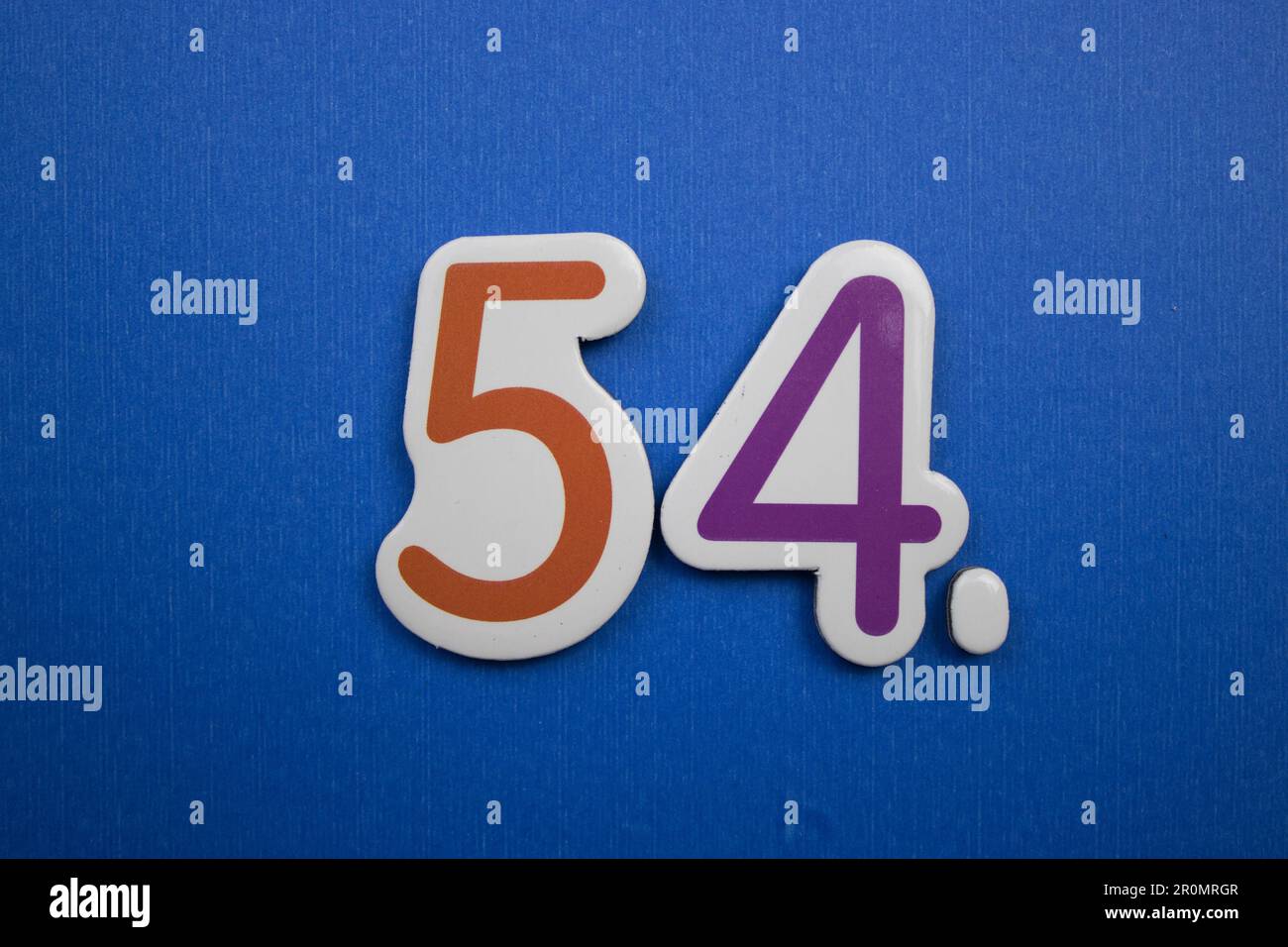 The number 54, placed on a blue background, photographed from above ...