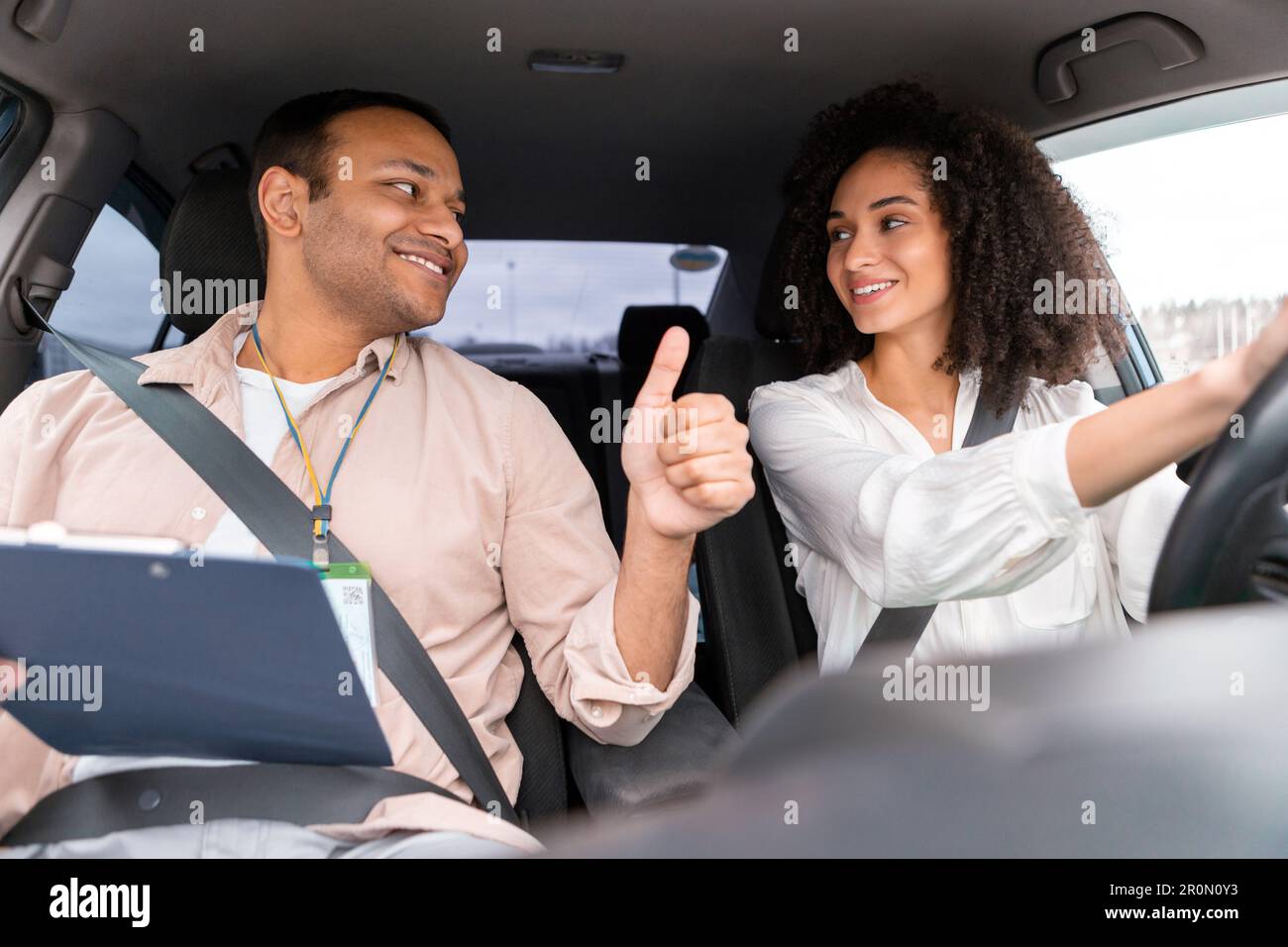 Instructor Man Gesturing Thumbs Up To Driver Woman Driving Car Stock ...