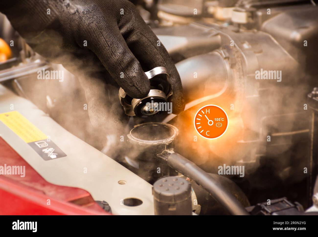 Auto mechanic hand opens the radiator cap with steam escaping around the engine compartment from the high heat,water temp gauge symbol with high tempe Stock Photo