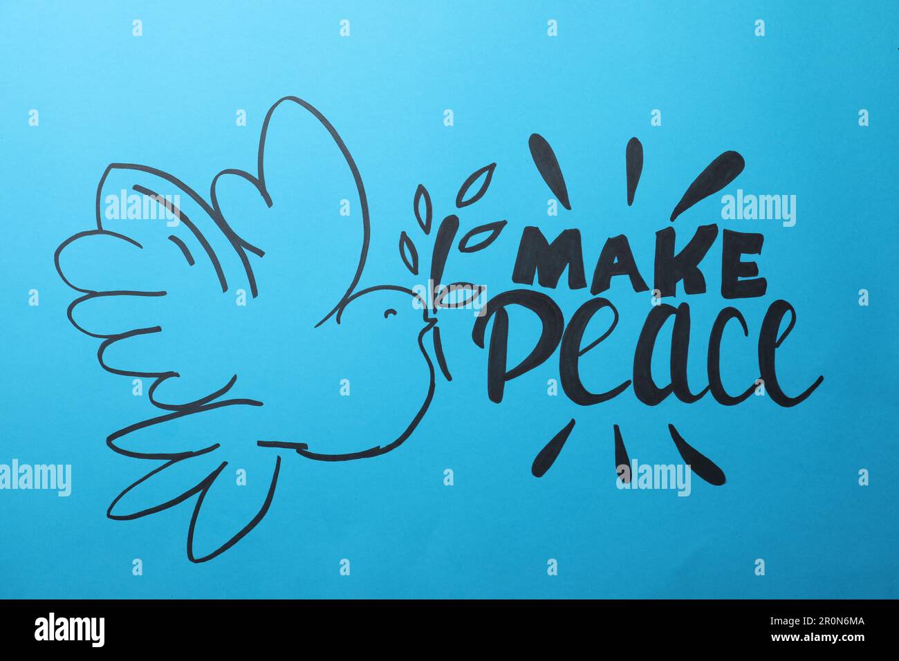 Beautiful phrase Make Peace with pigeon on blue background Stock Photo
