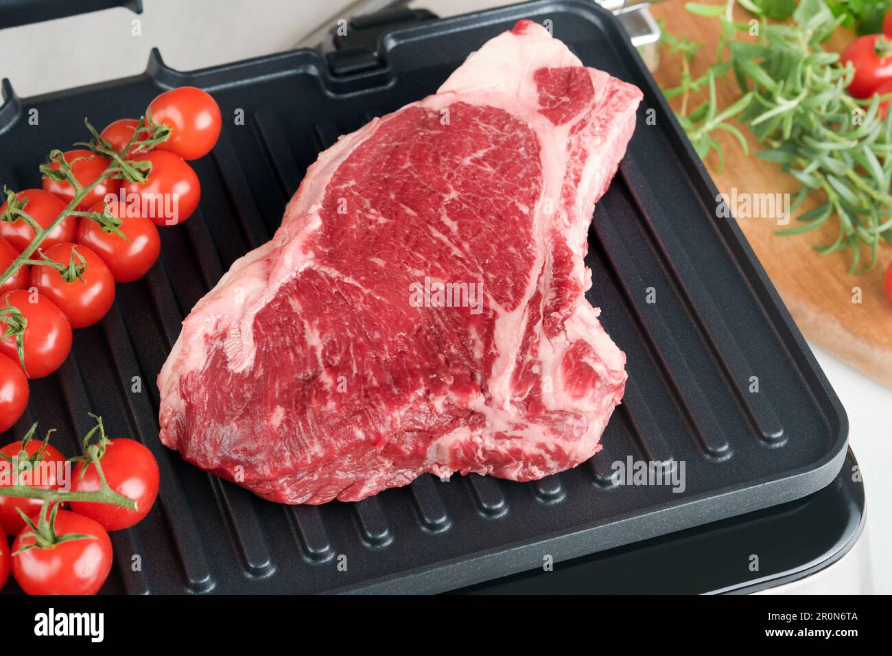 Raw prime steaks on electric grill. Black angus prime meat steaks