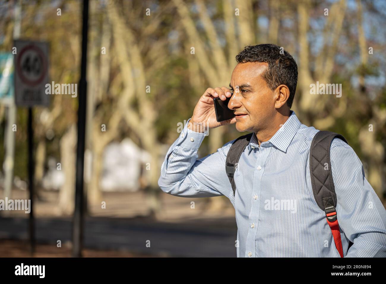 Young latin man talking on mobile phone with copy space. Stock Photo