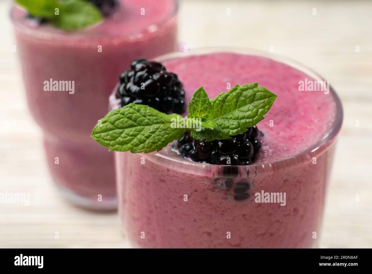 https://c8.alamy.com/comp/2R0N8AF/glass-of-blackberry-smoothie-with-mint-and-berries-on-light-table-closeup-2R0N8AF.jpg