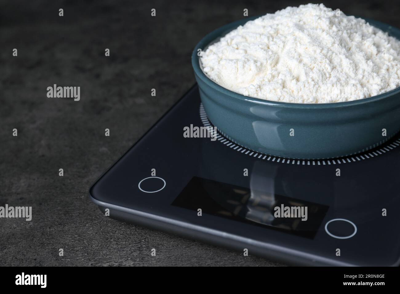 https://c8.alamy.com/comp/2R0N8GE/electronic-scales-with-flour-on-black-table-closeup-space-for-text-2R0N8GE.jpg