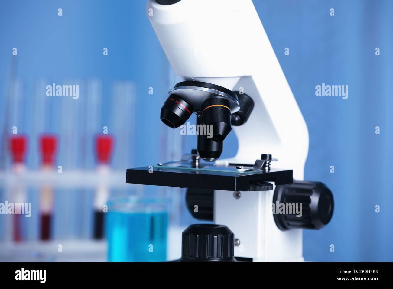 Modern medical microscope with glass slide in laboratory, closeup Stock