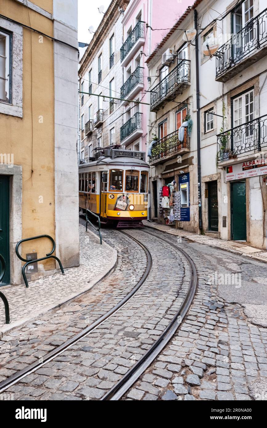 A tram squeezed through a street it barely fits