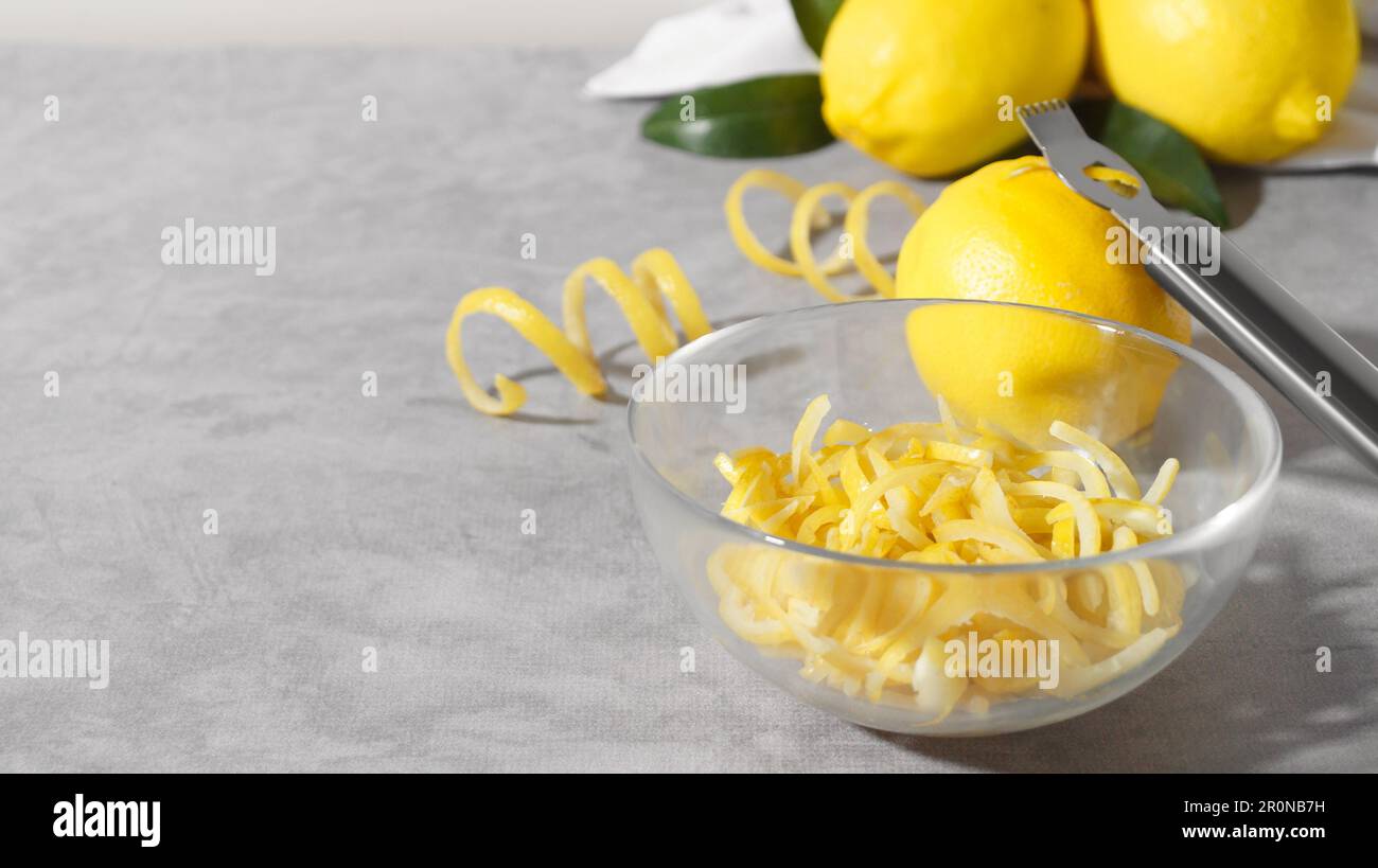 https://c8.alamy.com/comp/2R0NB7H/bowl-with-peel-pieces-fresh-lemons-and-zester-on-grey-table-space-for-text-2R0NB7H.jpg