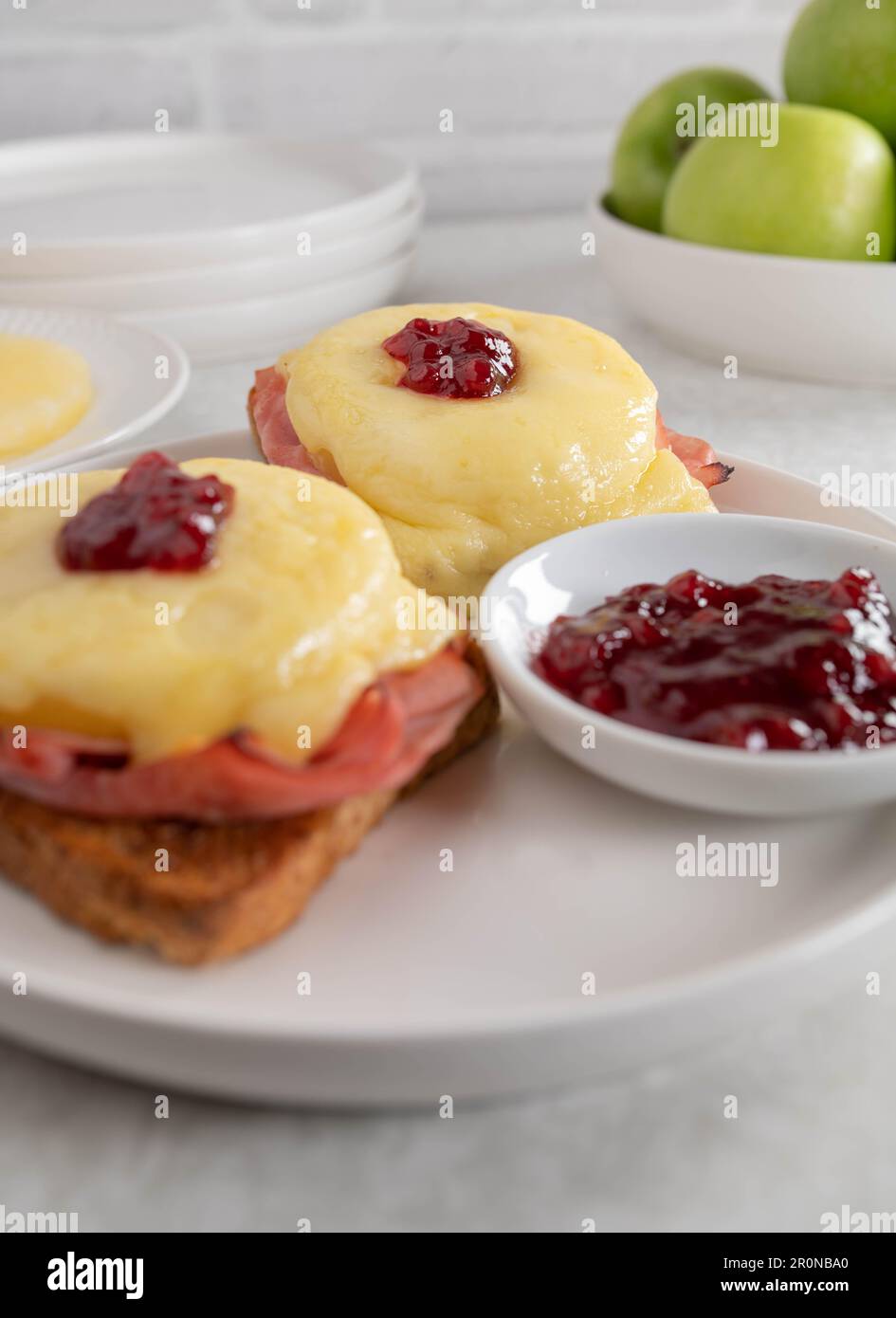 Toast hawaii with gratinated ham, pineapple, cheese and cranberry sauce Stock Photo