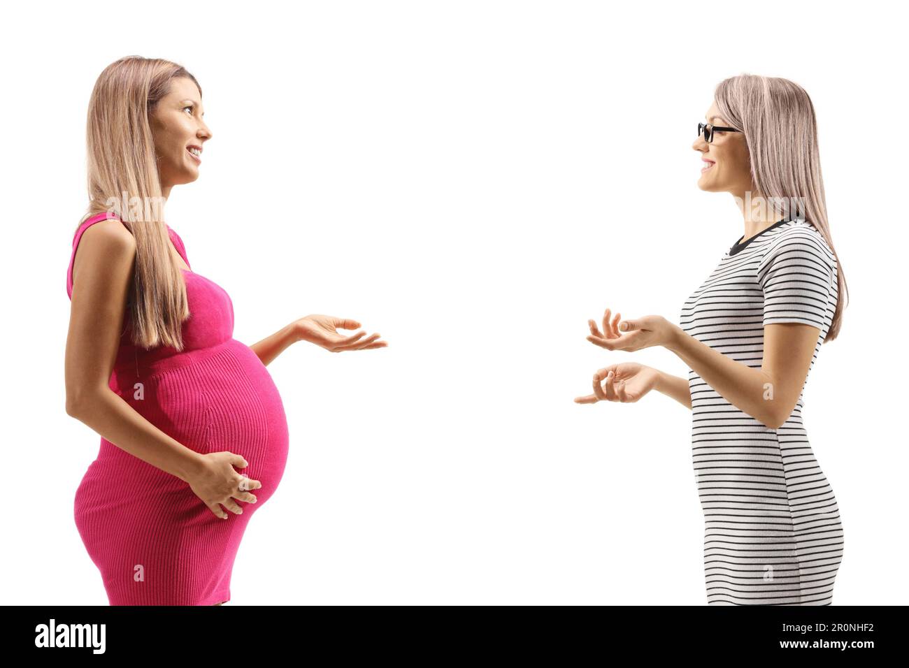 Profile shot of a pregnant woman having a conversation with another woman isolated on white background Stock Photo