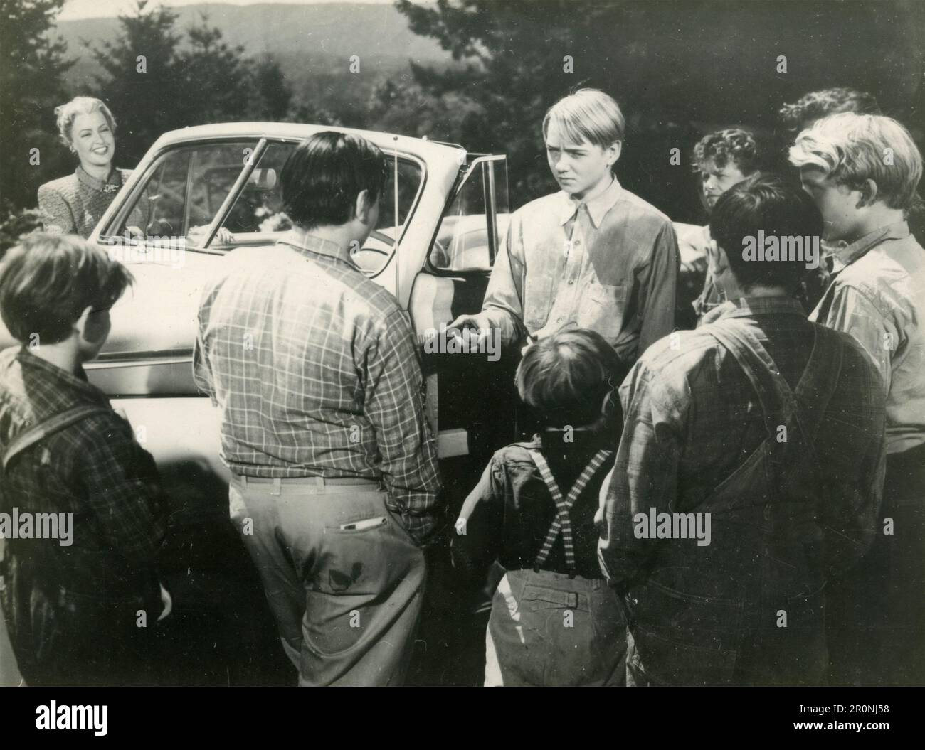Movie still with a group of teenagers around a car, unidentified movie from the 1950s Stock Photo