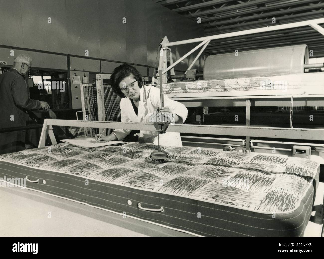 Woman at work testing mattresses in a factory, UK 1966 Stock Photo