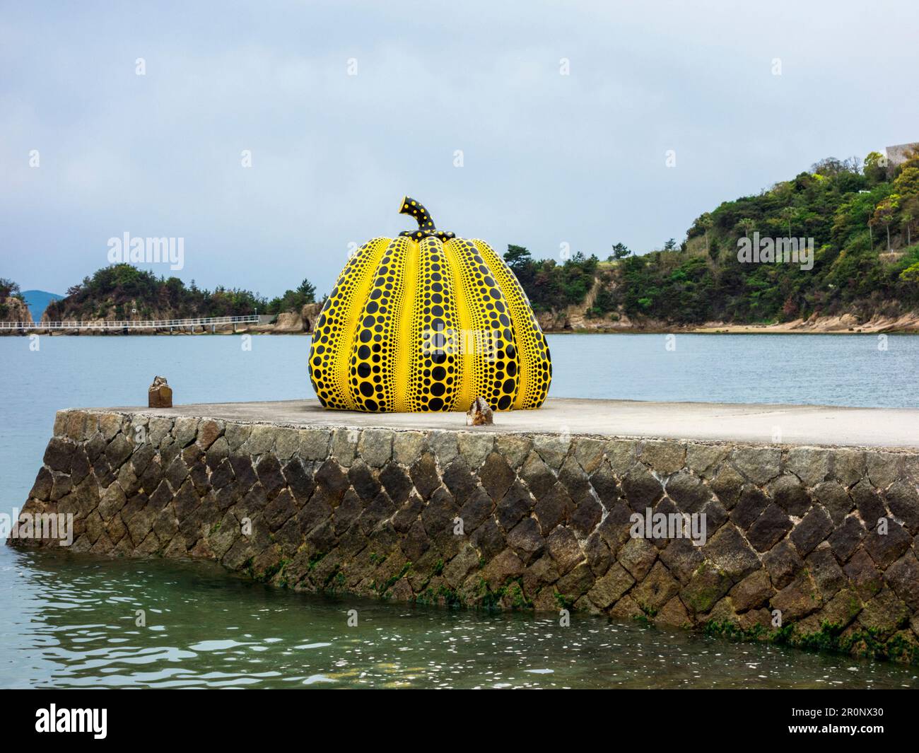 Yellow pumpkin sculpture by Japanese artist Yayoi Kusama on the island of Naoshima, Japan. The island hosts a collection of contemporary art that is m Stock Photo