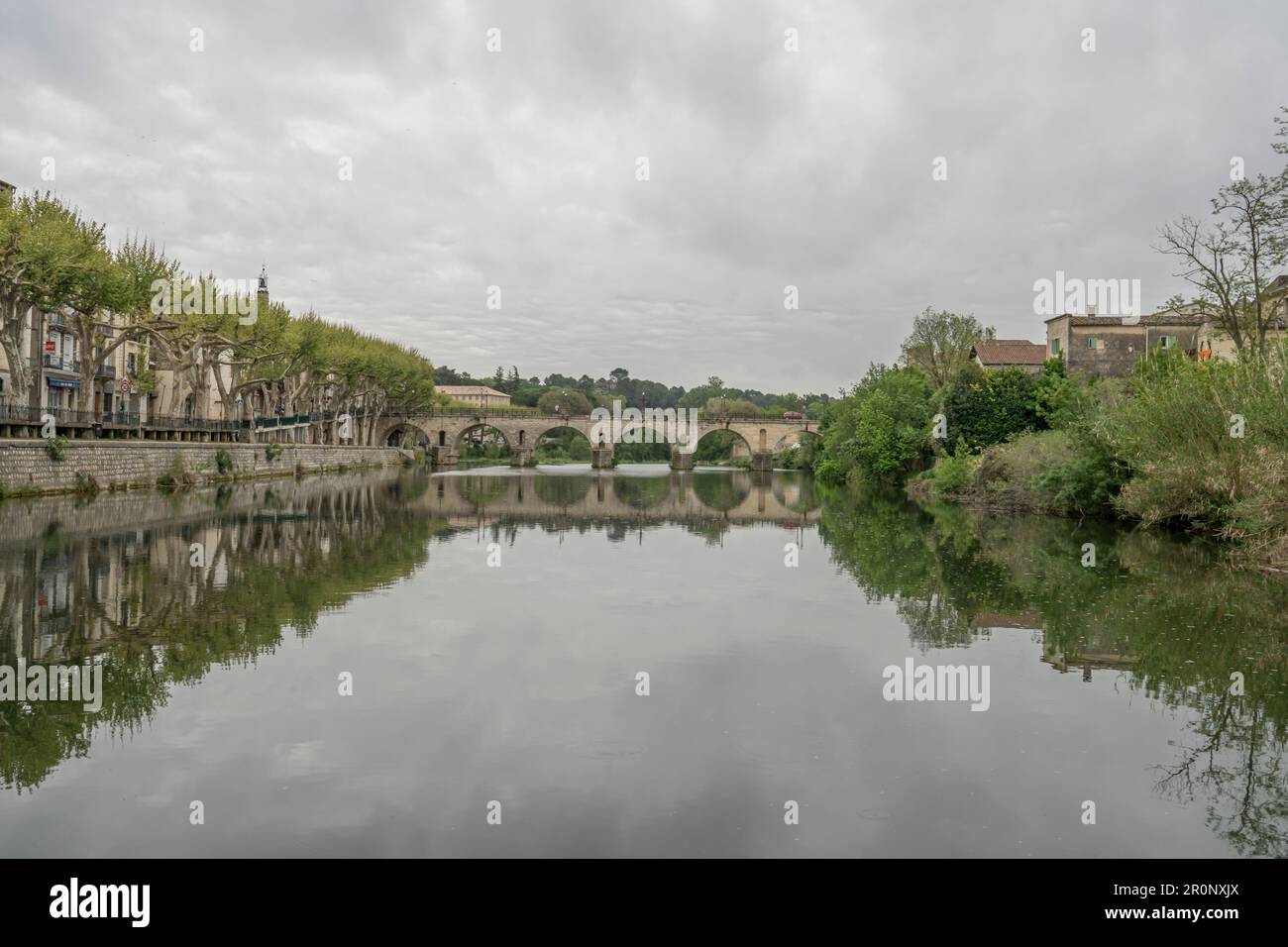 View of the Sommieres Roman bridge reflecting in the Vidourle river Stock Photo