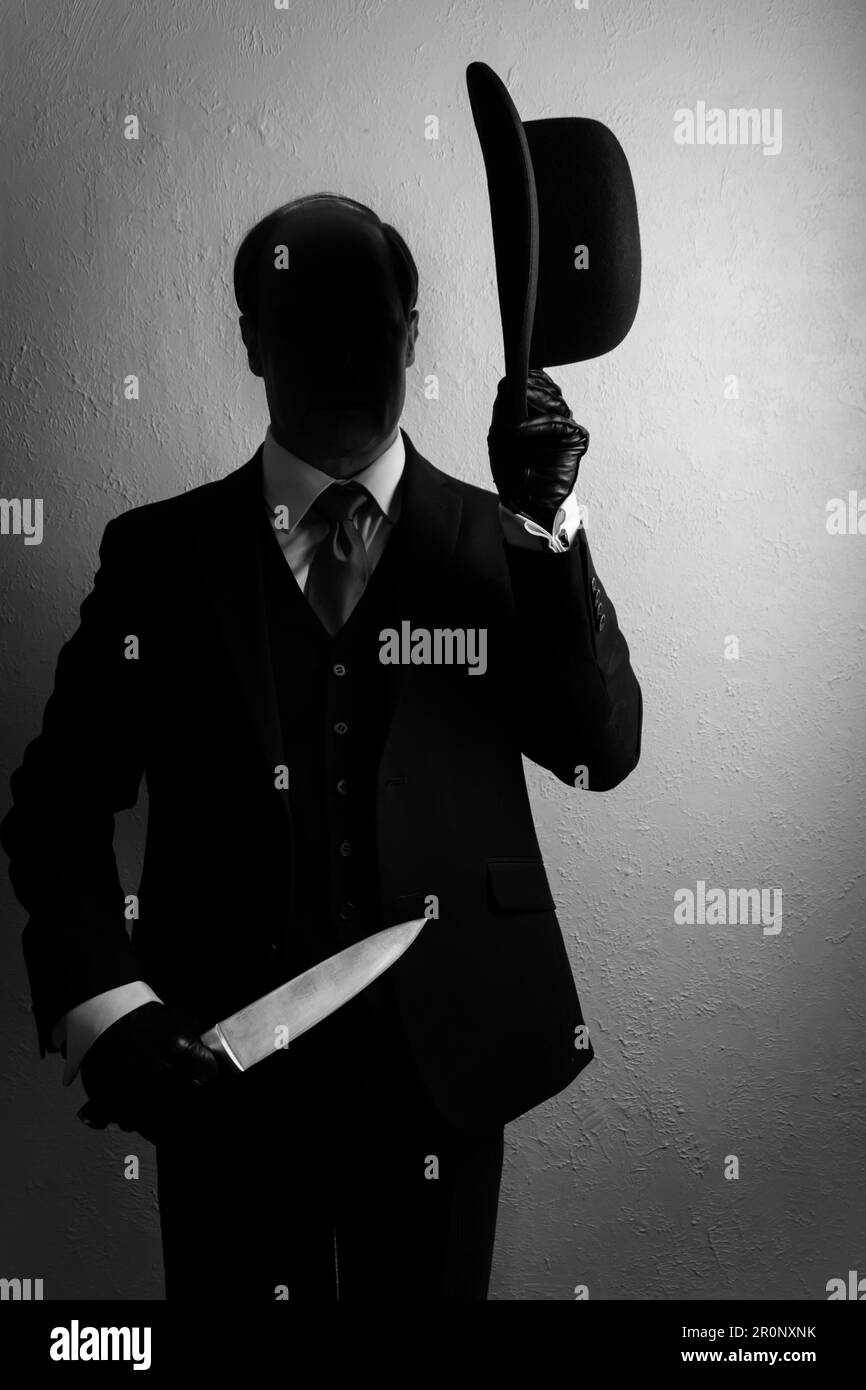 Portrait of Shadow Man in Dark Suit Holding Bowler Hat and Sharp Knife. Concept of Horror Movie Murderer. Stock Photo