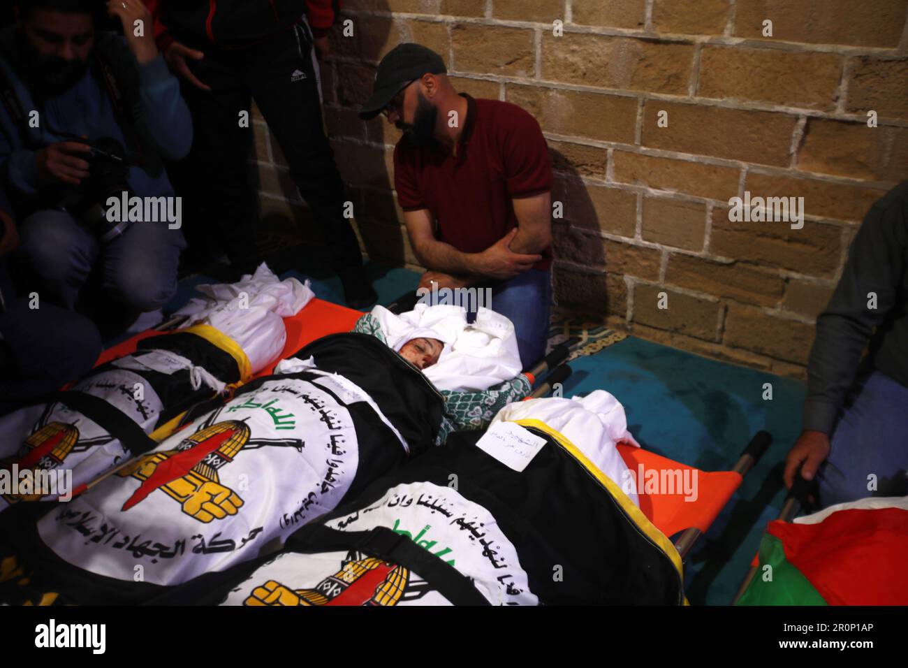 Gaza City, Palestine. 9th May 2023. Mourners gather around the body of Palestinian boy Ali Ezzedine, son of Islamic Jihad member Tareq Ezzedine, at a morgue in Gaza. They were both killed in a pre-dawn Israeli air raid. The Israeli army said it killed three leaders of the Islamic Jihad militant group in air strikes, which left at least nine dead according to the Palestinian territory's Hamas-controlled health ministry, adding that women and children were among them. Stock Photo