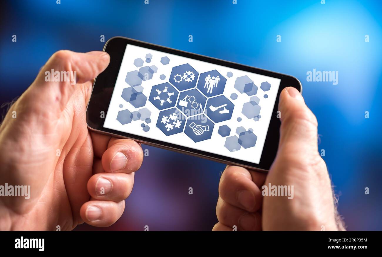 Hand holding a smartphone with teamwork concept Stock Photo - Alamy