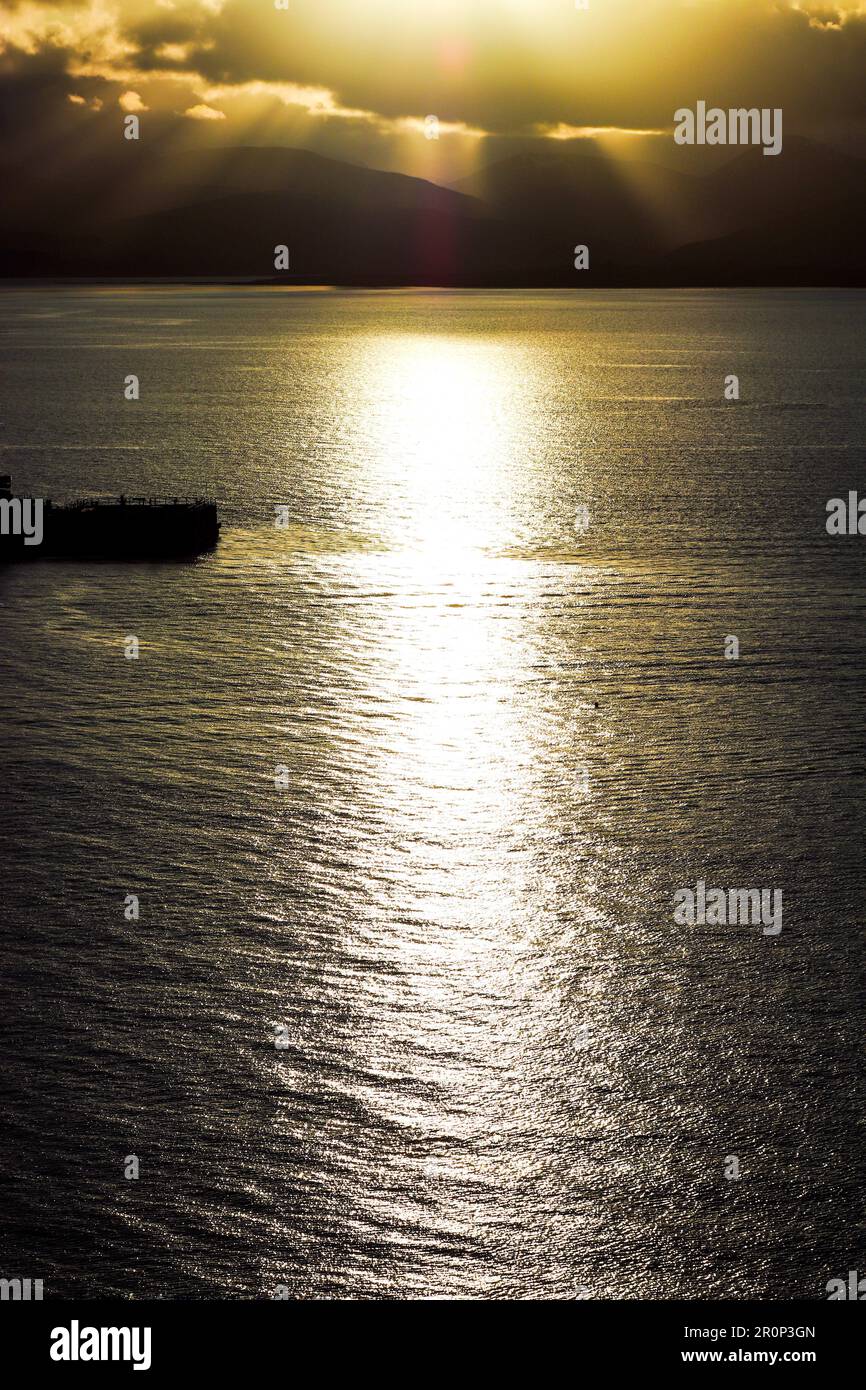 A vertical aerial view of the reflection of a golden sunset sky over ...