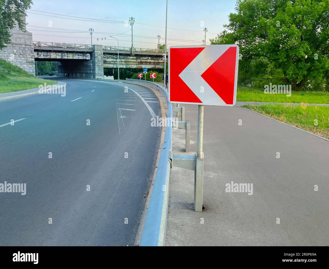 Left turn sign: Road signs warn of a sharp turn on a narrow, rocky road. Traffic safety. Road barrier. Attention concept. Stock Photo