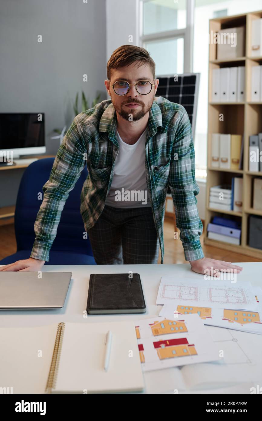 Solar energy project engineer leaning on desk with documentation Stock Photo