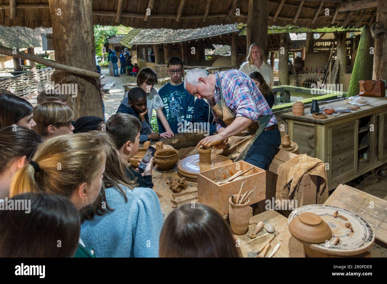 School children watching pottery wheel demonstration at the openair