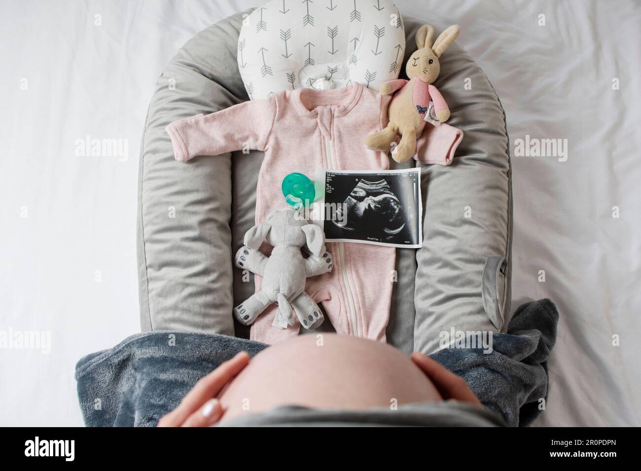 Pregnant belly and stuff for a baby. Waiting for the baby concept. Ready for a baby. Ultrasound picture of a baby. Stock Photo
