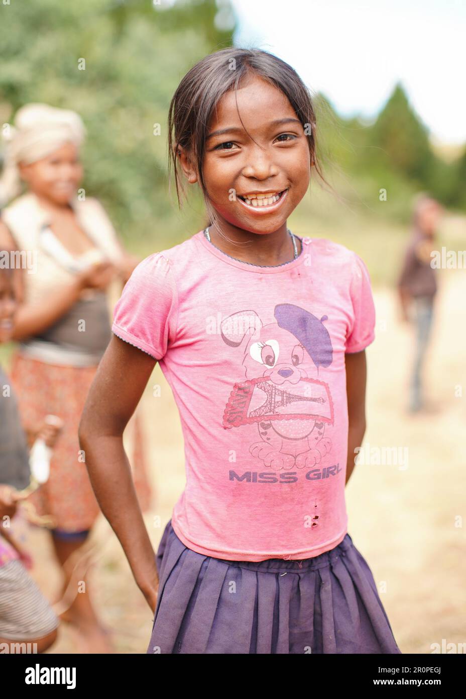 Tsiafahy, Madagascar - April 25, 2019:  Small girl in pink t shirt donated by tourists smiling into camera. People in Madagascar, especially Malagasy Stock Photo