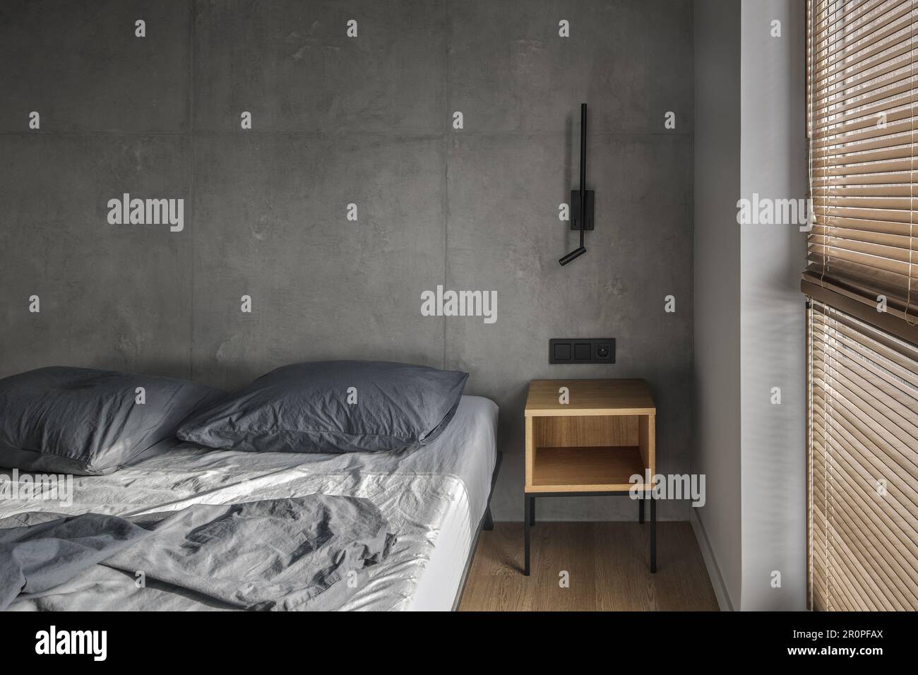 Minimalistic black wall light in modern bedroom interior in grey and