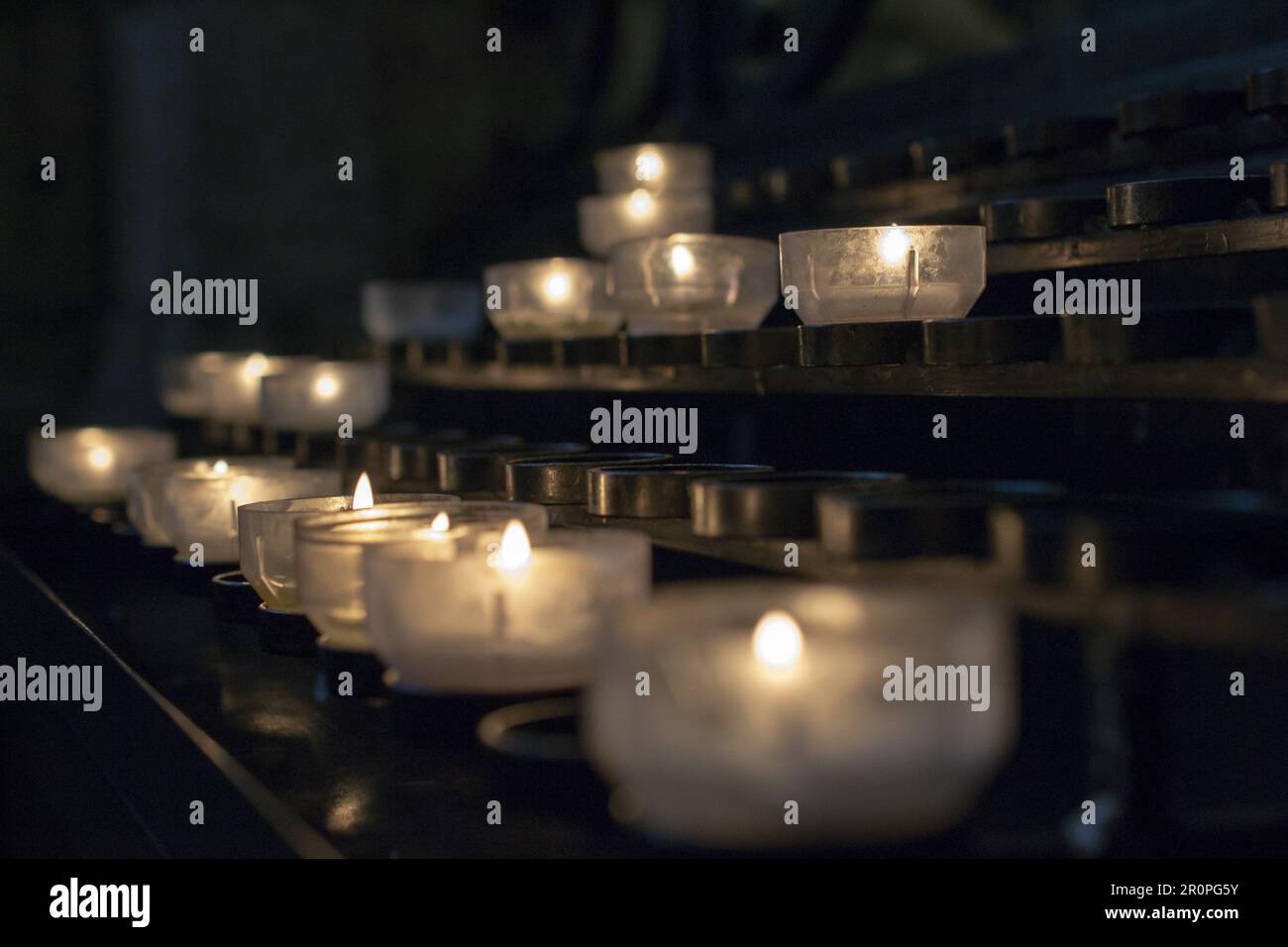 Votive prayer candles inside a catholic church on a candle rack Stock Photo Alamy