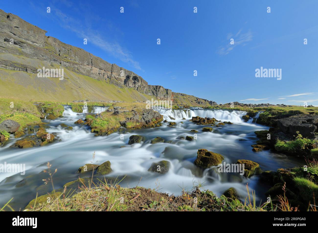 A picturesque scene featuring a tranquil stream winding its way through ...
