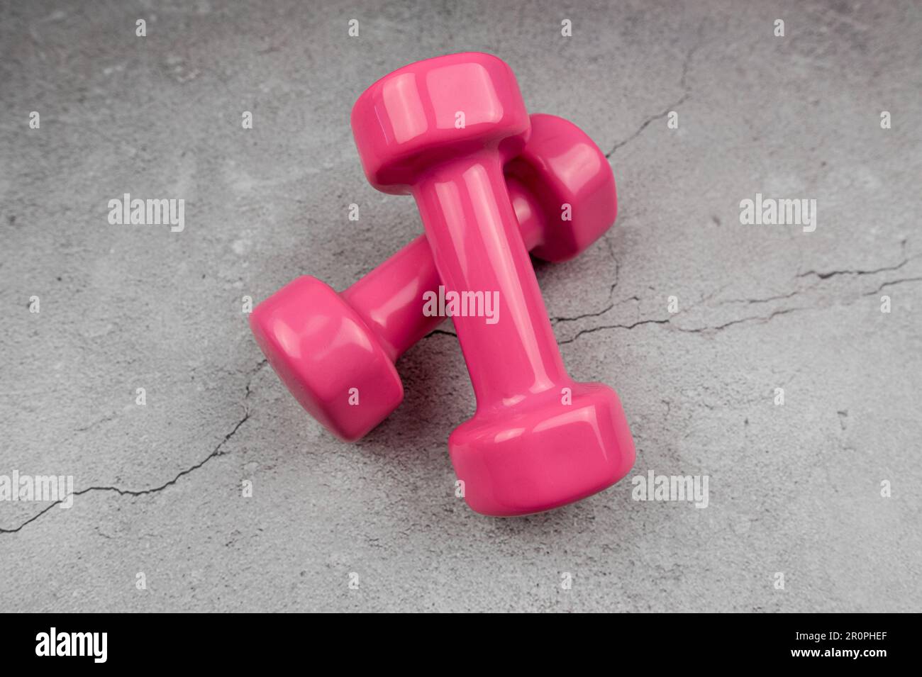 Equipment for sport exercise. Fitness background. Dumbbells, expander on  pastel pink background top view copy space Stock Photo