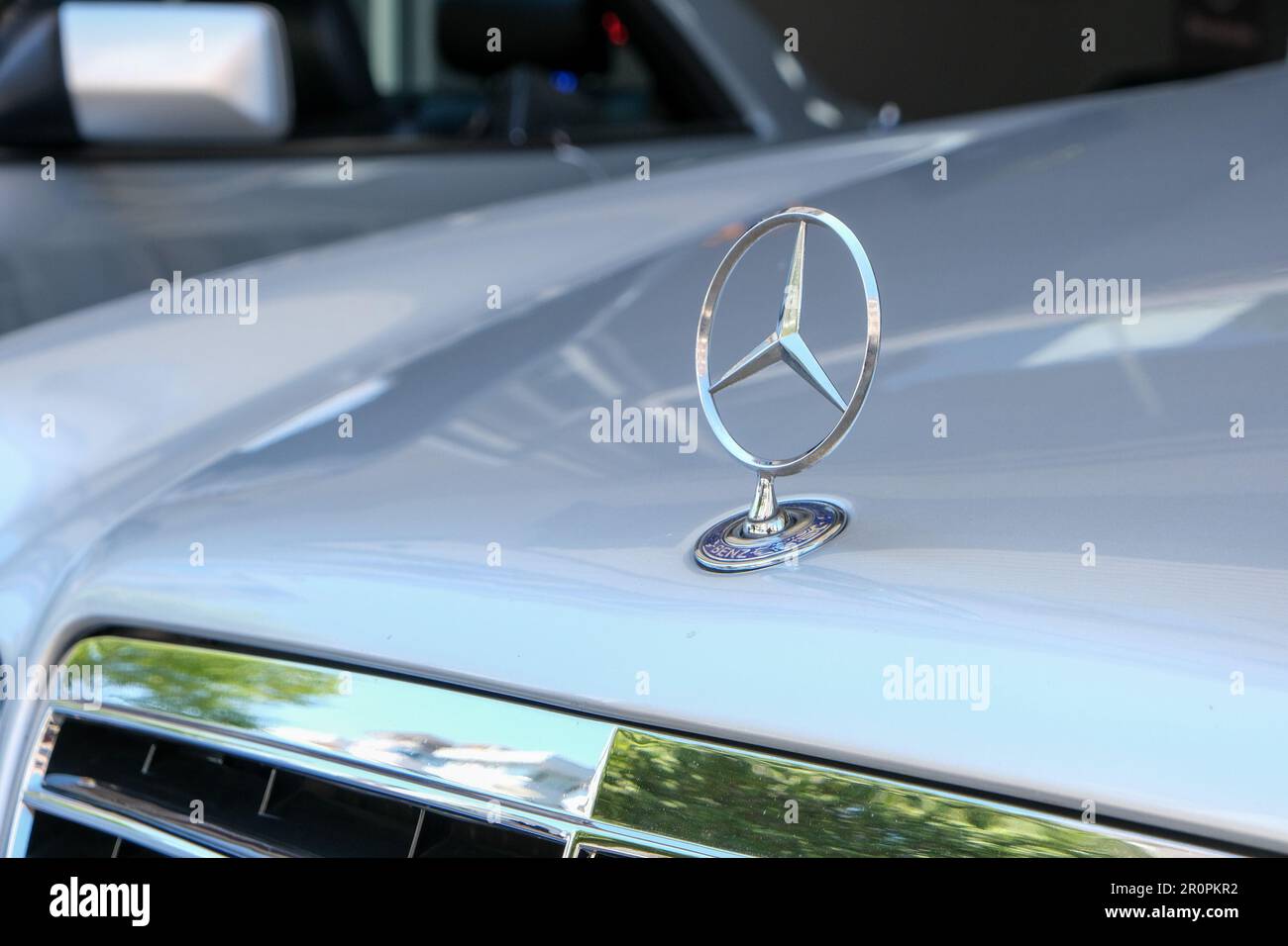 Closeup of old original metal star logo of Mercedes Benz at hood of car. Selective focus of old Mercedes logo. Stock Photo