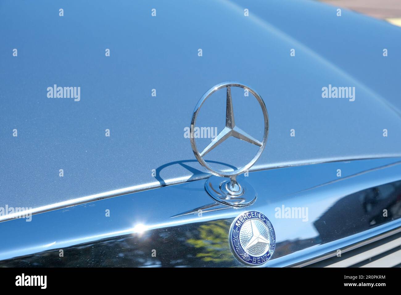 Closeup of old original metal star logo of Mercedes Benz at hood of car. Selective focus of old Mercedes logo. Stock Photo