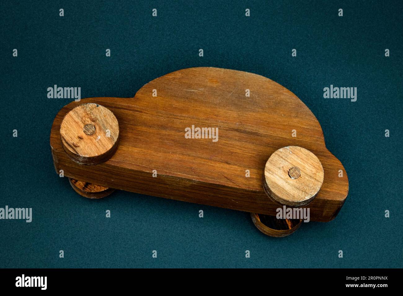 wooden toy car made from cherry wood, isolated on a black background, crashed on its side, top view Stock Photo