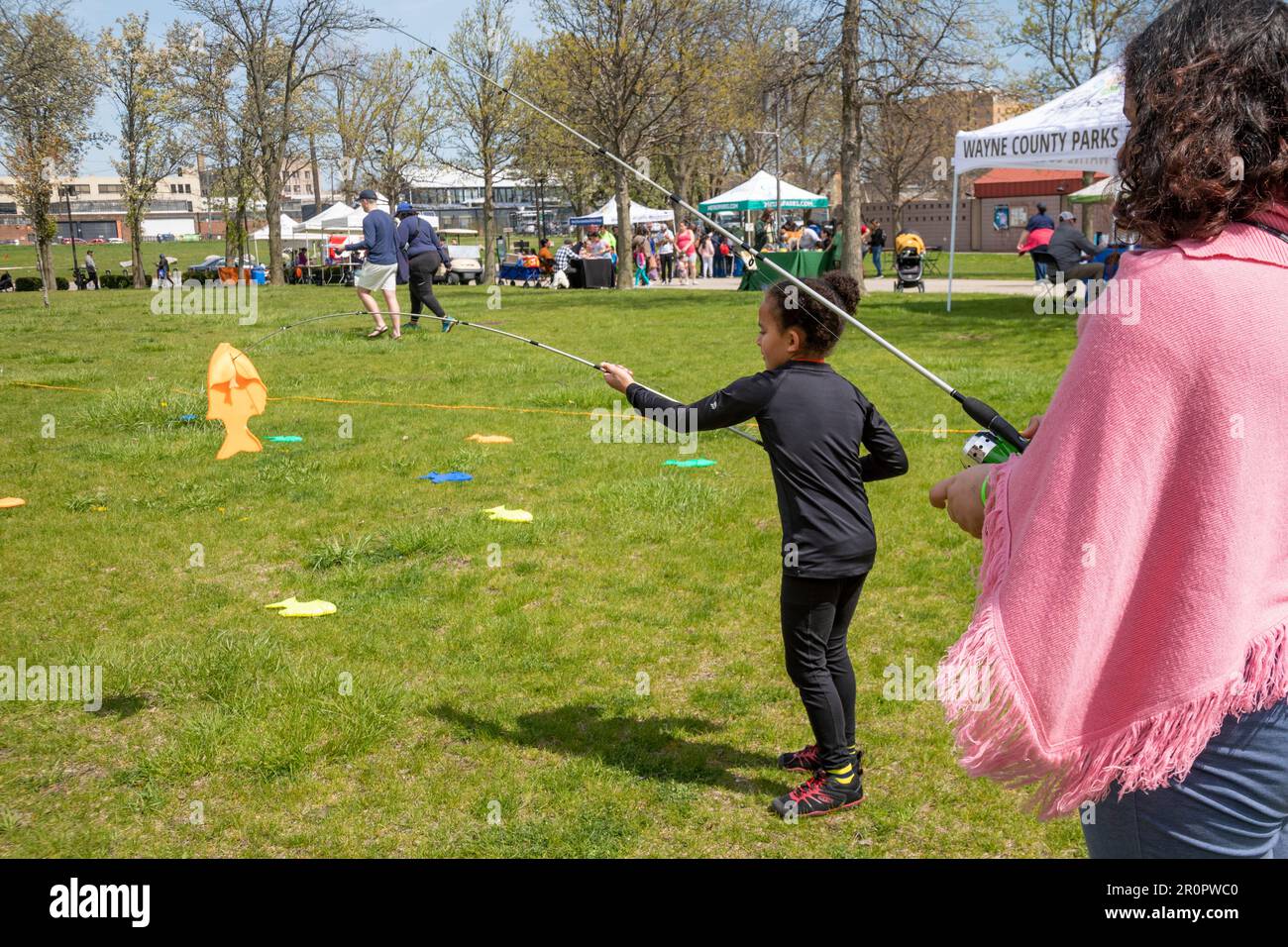 Detroit, Michigan - Children learn to fish using plastic fish at Milliken State Park. Stock Photo