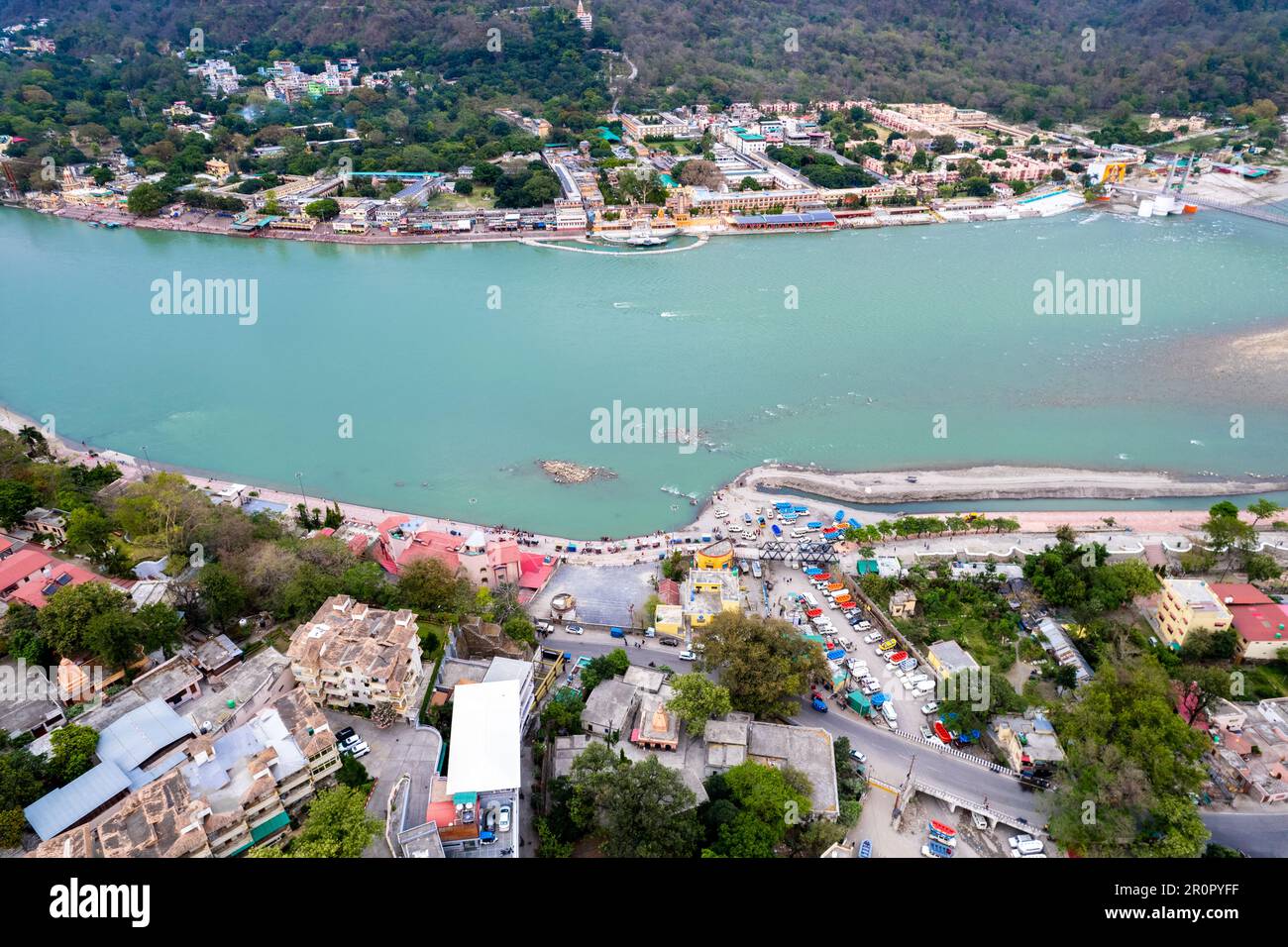 aerial drone shot over ram setu jhula suspension bridge with temples on the bank of river ganga in the holy spiritual city of Rishikesh Haridwar Stock Photo